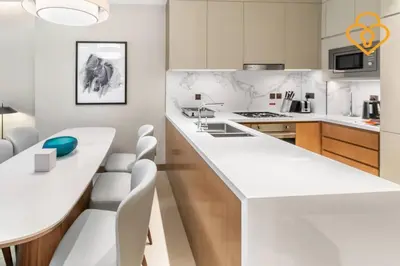 a kitchen with a white counter and white chairs at Keysplease 2BR Apt Address Opera Minutes to Dubai Mall, Downtown 29 in Dubai