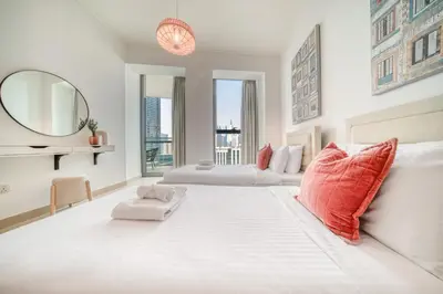 a large white bedroom with two beds and a mirror at Burj Vista Tower 1 - City View, Downtown Dubai - Mint Stay in Dubai