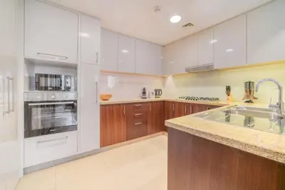 a large kitchen with white cabinets and a sink at Burj Vista Tower 1 - City View, Downtown Dubai - Mint Stay in Dubai