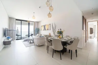a dining room and living room with a table and chairs at Frank Porter - The Address JBR in Dubai