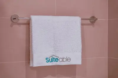 a white towel hanging on a towel rack in a bathroom at Sunset spot with breathtaking view by Suiteable in Dubai