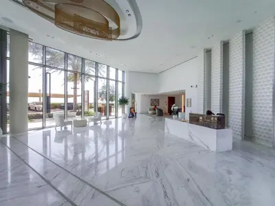 a large lobby with white marble floors and large windows at Sunset spot with breathtaking view by Suiteable in Dubai