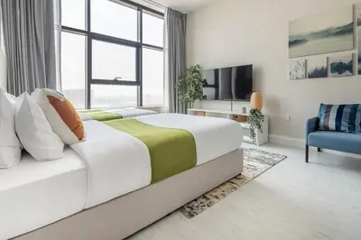 a bedroom with a large bed and a tv at Frank Porter - Square Tower in Dubai