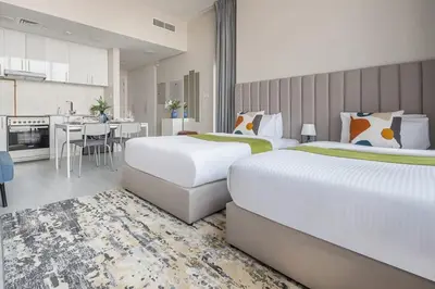 a hotel room with two beds and a kitchen at Frank Porter - Square Tower in Dubai