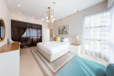 a bedroom with a white bed and a large window at Charming Brand New 2BR close to the Beach in Dubai