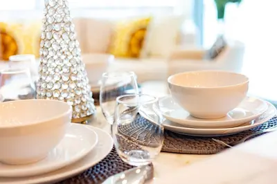 a table with plates and bowls and glasses on it at Charming Brand New 2BR close to the Beach in Dubai