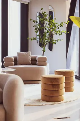 a living room with a couch and two stools at Magnificent 3BR Spectacular Canal & Burj View in Dubai