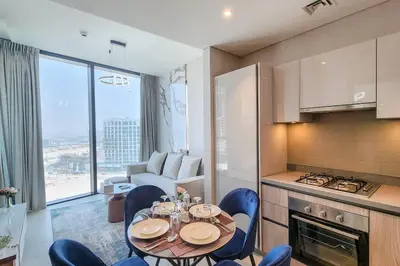 a kitchen with a table and chairs in a room at STAY BY LATINEM Luxury 1BR Holiday Home W1006 near Burj Khalifa in Dubai