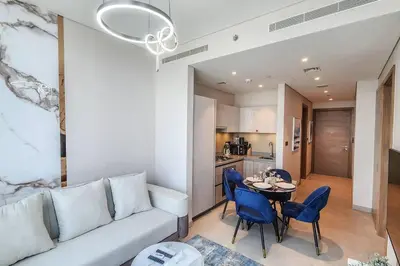 a living room with a couch and a table and chairs at STAY BY LATINEM Luxury 1BR Holiday Home W1006 near Burj Khalifa in Dubai