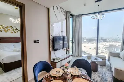 a hotel room with a table and chairs and a bedroom at STAY BY LATINEM Luxury 1BR Holiday Home W1006 near Burj Khalifa in Dubai