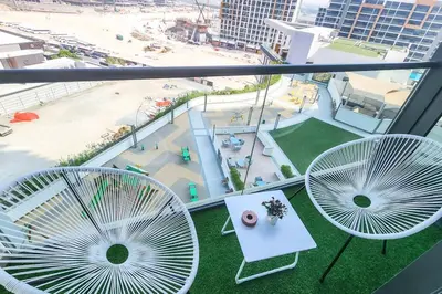 two chairs and a table on a balcony with a view of a city at STAY BY LATINEM Luxury 1BR Holiday Home W1006 near Burj Khalifa in Dubai