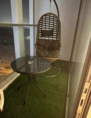 a chair and a glass table in a room at Chez Fouzia in Dubai