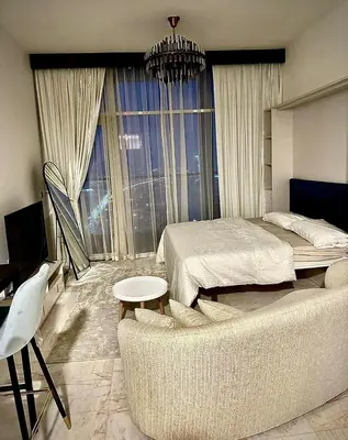 a bedroom with a bed and a table and a couch at Chez Fouzia in Dubai