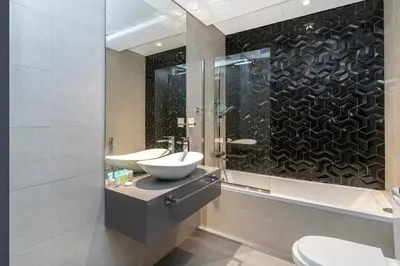 a bathroom with two sinks and a glass shower at Elegant Studio in City Center with Balcony in Dubai