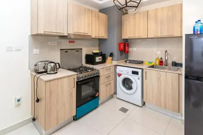a kitchen with a stove and a washing machine at Elegant Studio in City Center with Balcony in Dubai