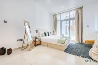 a bedroom with a bed and a large window at Upbeat 1BR at Pantheon Elysee Jumeirah Village Circle by Deluxe Holiday Homes in Dubai