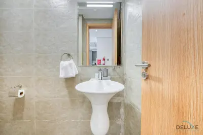 a bathroom with a white sink and a mirror at Upbeat 1BR at Pantheon Elysee Jumeirah Village Circle by Deluxe Holiday Homes in Dubai