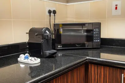 a black counter top with a microwave on top of it at Shams Apart on JBR - 1 Bedroom - Marina View in Dubai