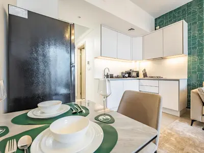 a kitchen and dining room with a table and chairs at Superb Studio in Luma 21-JVC in Dubai