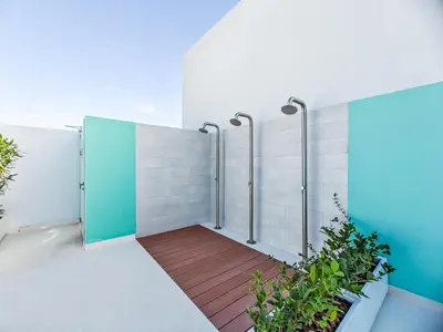 a bathroom with a shower stall with a wooden floor at Superb Studio in Luma 21-JVC in Dubai