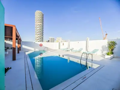 a swimming pool on the roof of a building at Superb Studio in Luma 21-JVC in Dubai
