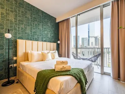 a bedroom with a bed with a green wall at Superb Studio in Luma 21-JVC in Dubai