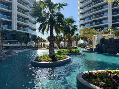 a swimming pool with palm trees in a resort at Keysplease Luxury 1 B/R Apt in Paramount Towers by Damac in Dubai