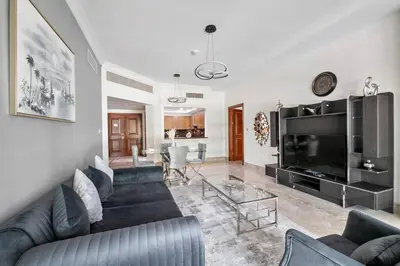a living room with a couch and a large television at StoneTree - Fairmont North 2 BR - Beach Access in Dubai