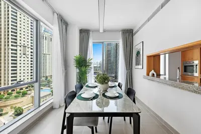 a dining room with a table and some windows at StoneTree - Attessa Tower 1BR - Amazing View in Dubai