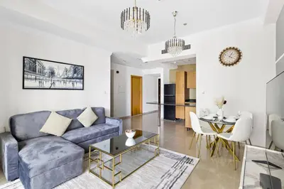 a living room with a blue couch and a table at StoneTree - Marina Crown 1 BR - Dubai Marina in Dubai