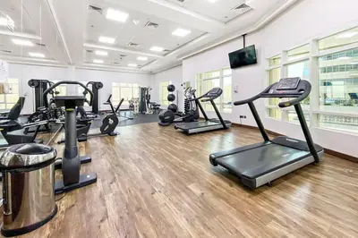 a gym with several tread machines in a room at StoneTree - Marina Crown 1 BR - Dubai Marina in Dubai