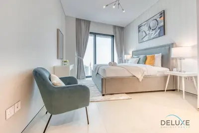 a bedroom with a bed and a chair at Stylish 1BR in Prime Location, Book Your Stay by Deluxe Holiday Homes in Dubai