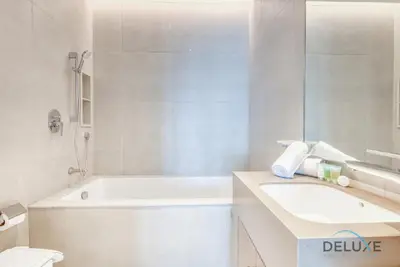 a bathroom with a tub and a sink and a toilet at Stylish 1BR in Prime Location, Book Your Stay by Deluxe Holiday Homes in Dubai