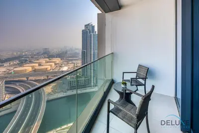 a balcony with a chair and a view of a city at Stylish 1BR in Prime Location, Book Your Stay by Deluxe Holiday Homes in Dubai