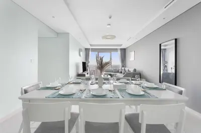 a white dining room with a white table and chairs at StoneTree - Paramount 3 BR - Infinity Pool in Dubai