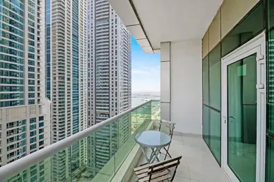 a balcony with a table and views of skyscrapers at StoneTree - Marina Pinnacle 1 BR - Partial Marina View in Dubai