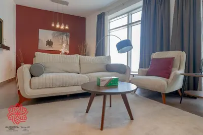 a living room with a couch and two chairs and a table at Alashrafia Saray- Central 2BR apartment in Downtown in Dubai