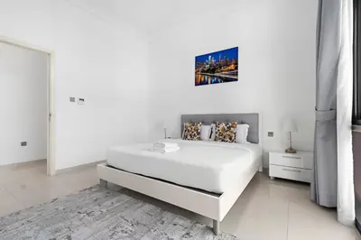 a white bedroom with a large white bed in it at StoneTree - Pelham Villa 3 BR - Damac Hills in Dubai