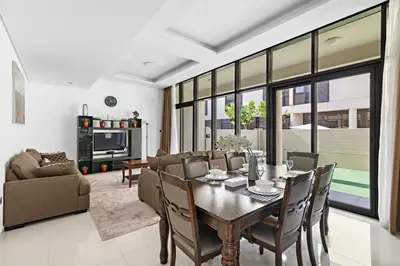 a living room with a dining room table and chairs at StoneTree - Pelham Villa 3 BR - Damac Hills in Dubai