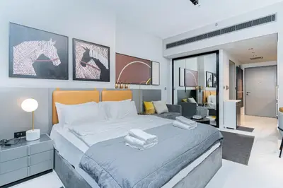 a bedroom with a large bed and a living room at MAG 318 Studio Walk to Dubai Mall in Dubai
