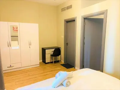 a bedroom with a bed and a desk and a chair at Royal Manor- Marina Diamond 2 in Dubai