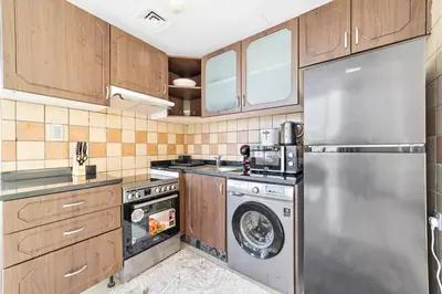 a kitchen with a stainless steel refrigerator and a dishwasher at StoneTree - Indigo Tower 1BR - Panoramic View in Dubai