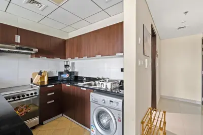 a kitchen with a washer and a washing machine at Stylish Sports City Studio Golf View PoolGym in Dubai
