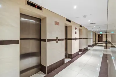 a row of elevator doors in a building at Stylish Sports City Studio Golf View PoolGym in Dubai