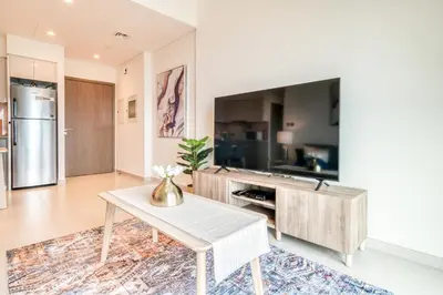 a living room with a table and a tv at Burj Royale, Downtown Dubai - Mint Stay in Dubai
