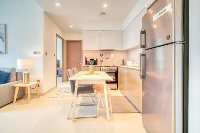 a kitchen with a table and a refrigerator at Burj Royale, Downtown Dubai - Mint Stay in Dubai