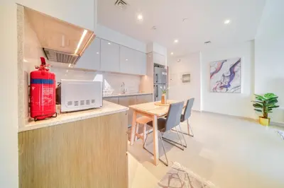 a kitchen and dining room with a red appliance on a counter at Burj Royale, Downtown Dubai - Mint Stay in Dubai