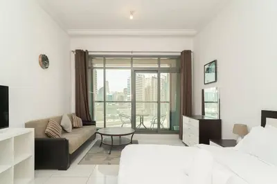 a bedroom with a bed and a couch and a table at StoneTree - Elegant Studio in Business Bay in Dubai