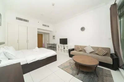 a bedroom with a bed and a couch and a table at StoneTree - Elegant Studio in Business Bay in Dubai