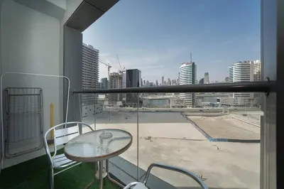 a balcony with a table and a view of a city at StoneTree - Elegant Studio in Business Bay in Dubai
